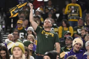 MINNEAPOLIS, MINNESOTA - DECEMBER 31: A Green Bay Packers fan cheers during the fourth quarter of a game against the Minnesota Vikings at U.S. Bank Stadium on December 31, 2023 in Minneapolis, Minnesota.